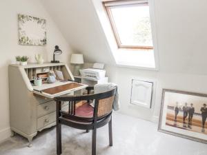 an attic office with a desk and a window at Rowan Tree House in Brechin