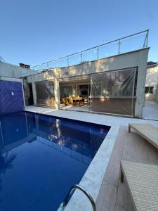 ein Haus mit einem Swimmingpool davor in der Unterkunft Casa Riviera Prime in Colônia de Férias