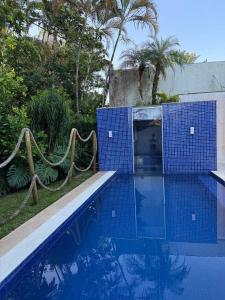 a swimming pool with blue tile around it at Casa Riviera Prime in Riviera de São Lourenço