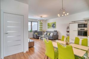 a kitchen and living room with a table and yellow chairs at City Center Appartment with parking in Trnava