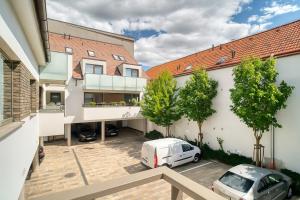 a white car parked in a parking lot next to a building at City Center Appartment with parking in Trnava