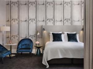 a bedroom with a bed and a blue chair at Fable Auckland, MGallery in Auckland