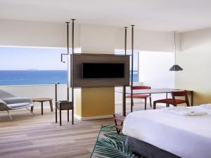 a hotel room with a bed and a television at Mercure Rio Boutique Hotel Copacabana in Rio de Janeiro