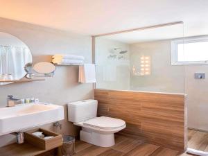 a bathroom with a toilet and a sink and a shower at Mercure Rio Boutique Hotel Copacabana in Rio de Janeiro +99 photos