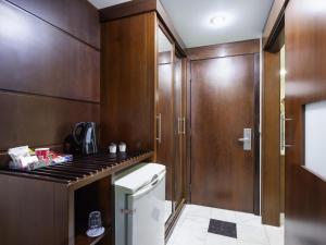 een kleine keuken met houten kasten en een fornuis bij Mercure Sao Paulo Grand Plaza Paulista in Sao Paulo