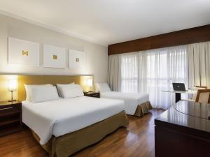 een hotelkamer met twee bedden en een bureau bij Mercure Sao Paulo Grand Plaza Paulista in Sao Paulo +94 foto's