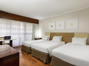 Ένα ή περισσότερα κρεβάτια σε δωμάτιο στο Mercure Sao Paulo Grand Plaza Paulista