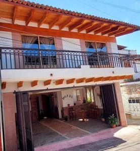 a house with a balcony and a patio at Hotel Johanan in Valle de Bravo
