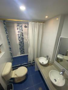 a bathroom with a toilet and a sink and a mirror at Apartamento Excalibur 11B junto al mar in Gaira