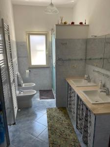a bathroom with two sinks and a toilet at Casa Relax in Simaxis