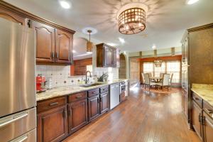 eine große Küche mit Holzschränken und einem Tisch in der Unterkunft Peaceful Big Sandy Home with Deck on Kentucky Lake! in Big Sandy