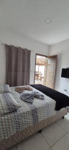 a bedroom with a large bed with a window at Pousada Coró in São Miguel do Gostoso