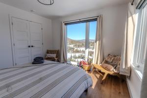 a bedroom with a bed and a large window at Le Panorama spa lake access in Saint Come