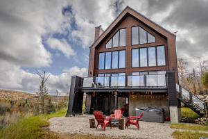 a house with four red chairs in front of it at Le Panorama spa lake access in Saint Come
