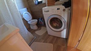 a bathroom with a washing machine and a toilet at Red Brick 