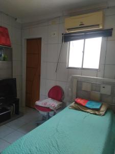 a bedroom with a bed and a window and a chair at Sebastião Arruda Júnior Recife Boa Vista in Recife