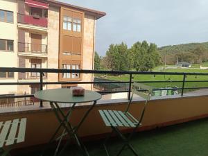 a table and a chair sitting on a balcony at Dúplex JUNI in Bádames