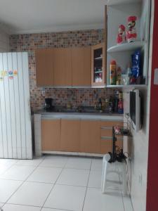 a kitchen with brown cabinets and a white tiled floor at Sebastião Arruda Júnior Recife Boa Vista in Recife +15 photos