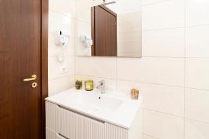 a white bathroom with a sink and a mirror at B&B Gaudio in San Marco Argentano