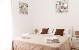 a white bedroom with a bed with towels on it at B&B Gaudio in San Marco Argentano +7 photos