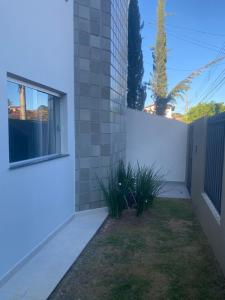 a backyard with a white fence and plants at Loft Design in Curvelo