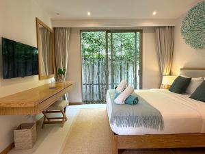 ein Schlafzimmer mit einem Bett und einem Schreibtisch und einem Schreibtisch in der Unterkunft Luxury 3BR Pool Villa near Blue Tree - Bang Tao in Chalong  + 32 Fotos