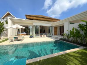 ein Swimmingpool vor einer Villa in der Unterkunft Luxury 3BR Pool Villa near Blue Tree - Bang Tao in Chalong 