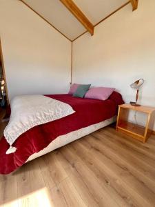 a bedroom with a bed and a lamp on a wooden floor at Tiny House Camino 3 in Puerto Natales