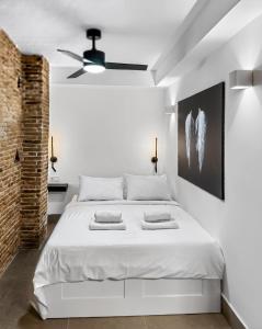 a white bedroom with a bed and a ceiling fan at Ρομαντική απόδραση με Χαμάμ in Athens