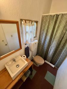 a bathroom with a sink and a toilet and a mirror at Loft en La Juanita in José Ignacio