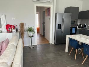un salon avec un canapé et une cuisine avec un réfrigérateur dans l'établissement Elegante appartamento con piscina privata, à Peschiera del Garda