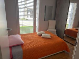 une chambre avec un lit orange avec deux serviettes dessus dans l'établissement Elegante appartamento con piscina privata, à Peschiera del Garda 17 autres photos