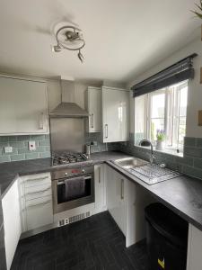 eine Küche mit weißen Schränken und einer Spüle in der Unterkunft Flat in Filton Mod Rolls Royce gkn in Bristol