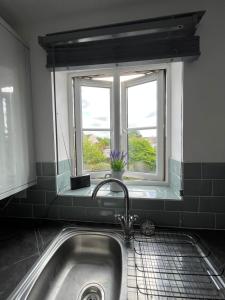 ein Waschbecken in einer Küche mit Fenster in der Unterkunft Flat in Filton Mod Rolls Royce gkn in Bristol