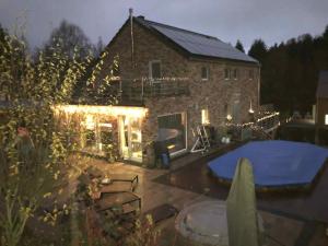 uma casa de tijolos com uma piscina em frente em « En toute simplicité chez Fabienne et Bruno » em Waimes