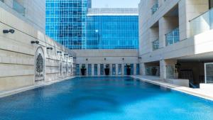 a large swimming pool in the middle of a building at DAMAC two bedroom furnished apartment in Amman