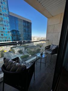 a balcony with chairs and a view of a building at DAMAC two bedroom furnished apartment in Amman