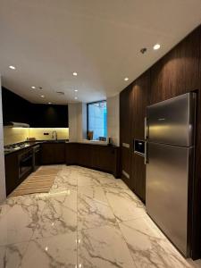 a large kitchen with a stainless steel refrigerator at Downtown pearl Amman in Amman