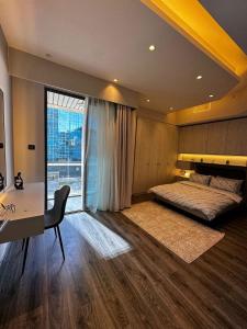 a bedroom with a bed and a desk and a window at DAMAC two bedroom furnished apartment in Amman +67 photos
