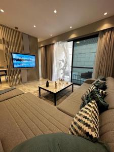 a living room with a couch and a tv at DAMAC two bedroom furnished apartment in Amman