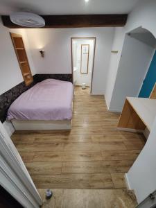 a small bedroom with a bed and a wooden floor at Chambre avec salle d'eau privée in Les Arcs sur Argens