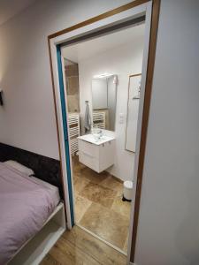 a bathroom with a bed and a sink and a mirror at Chambre avec salle d'eau privée in Les Arcs sur Argens