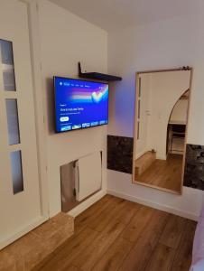 a room with a flat screen tv on the wall at Chambre avec salle d'eau privée in Les Arcs sur Argens