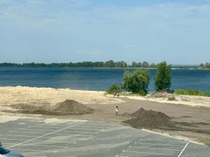 a person walking on a beach next to a body of water at Видова смарт-квартира в ЖК City Park in Cherkasy