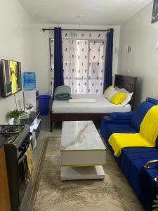 ein Wohnzimmer mit zwei Betten und einer Couch in der Unterkunft Tsavo Royal Suburb - blossom homes in Nairobi + 9 Fotos