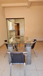 a glass table and chairs in a room at Pousada Shanti Quarto 3 in Dourados