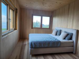 Una cama en una habitación pequeña con ventana. en Blickfang Bregenzerwald, en Langenegg