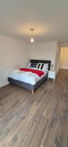 Un dormitorio con una cama y suelo de madera. en Morris lodge, en Dartford