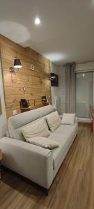 a living room with a couch and a wooden wall at studio Loubat pyrénée, ménage inclus in Arette +11 photos