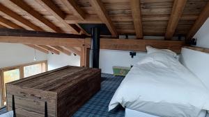 een slaapkamer met een bed en een houten plafond bij Chalet Roger in Montvalezan